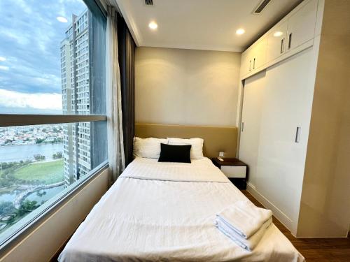 胡志明市The Landmark Vinhomes-Service Apartment的一间卧室设有一张床和一个大窗户