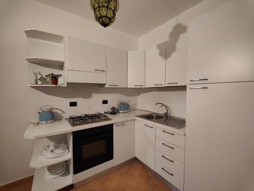 内比达Pan Di Zucchero的厨房配有白色橱柜、水槽和炉灶。