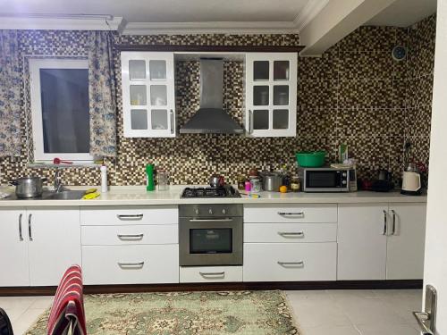 İznikDe La Terrasse IZNIK的厨房配有白色橱柜和炉灶。