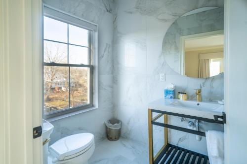 歌珊Orange Inn Boutique Hotel的一间带水槽、卫生间和镜子的浴室