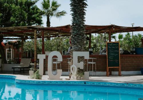 上钦查La Estancia Chincha Hotel的度假村前游泳池旁的标志