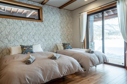 白马村　白馬　コテージ　チェスナッツ的两张床位于带窗户的房间内