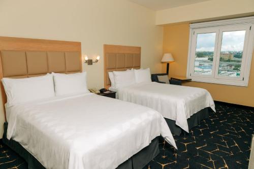圣萨尔瓦多圣萨尔瓦多假日酒店的酒店客房设有两张床和窗户。