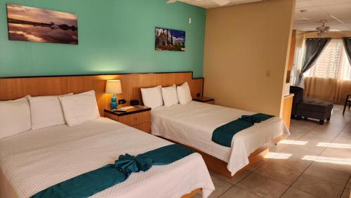 卡沃罗霍Combate Beach Resort的酒店客房,配有两张床和椅子