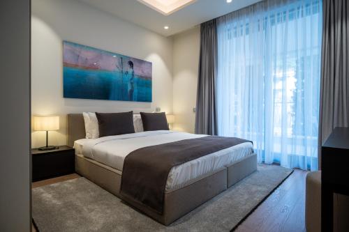 赫尔采格诺维Paloma Apartment - Portonovi Resort的一间卧室设有一张大床和一个大窗户