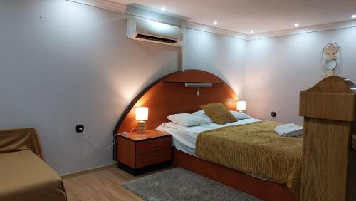 久洛Family Apartman的一间卧室配有一张大床和木制床头板