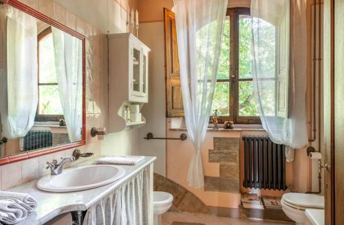 阿雷佐Villa San Filippo的一间带水槽和卫生间的浴室以及窗户。