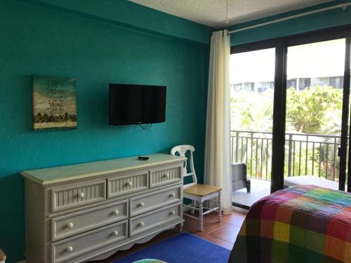 基韦斯特Moonlight Paradise的卧室配有一张床,墙上配有电视。