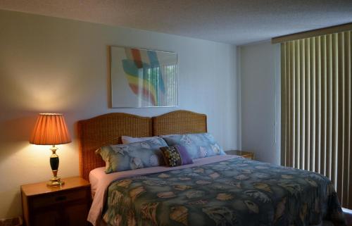 基韦斯特Paradise Found Cayo Hueso的一间卧室配有床、灯和窗户