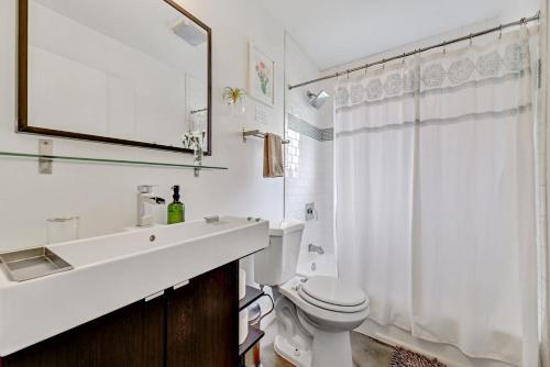 奥斯汀Sunny Mid Century Modern with Parking Patio and Fenced Yard by Lodgewell的白色的浴室设有水槽和卫生间。