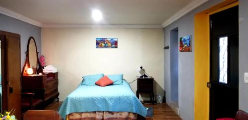 克萨尔特南戈Xelanos的一间卧室配有一张带蓝色棉被的床