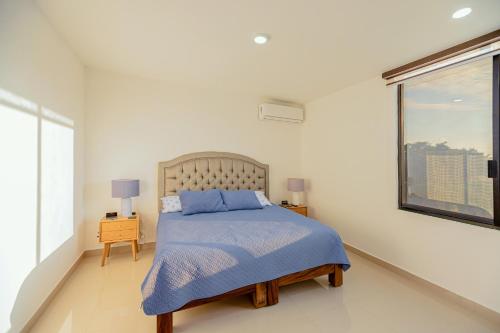 巴亚尔塔港Casa Amor的一间卧室配有一张带蓝色毯子的床和窗户。