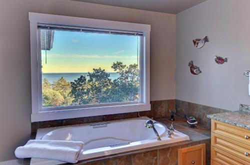 维多利亚Arbutus Hill的带浴缸的浴室和大窗户