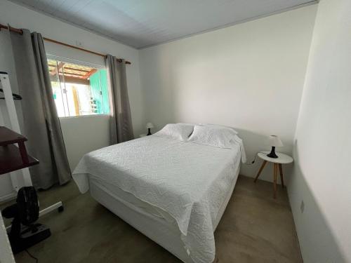 戈亚斯州上帕莱索Casa Esmeralda的白色的卧室设有床和窗户