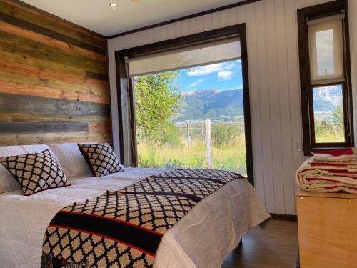 科伊艾科Cabaña Pampa Pinuer Coyhaique的一间卧室设有一张床和一个大窗户