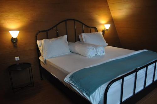 伦邦villa cikole kalaras的一间卧室配有带2个枕头和2盏灯的床