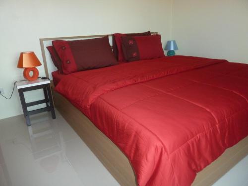 素辇府吉布公寓的一张带红色毯子和边桌的床