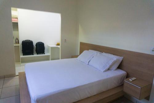 圣塔伦Casa Linda的卧室配有白色的床和窗户。