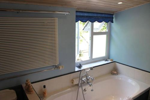 谢普顿马利特Enniskerry - The Loves Cottage的带浴缸的浴室和窗户