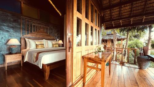 皮皮岛披披岛小木屋度假酒店的一间卧室配有一张床和一张木桌