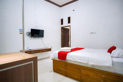 LampungRedDoorz at Jalan Basuki Rahmat Lampung的一间卧室配有一张床和一台电视。