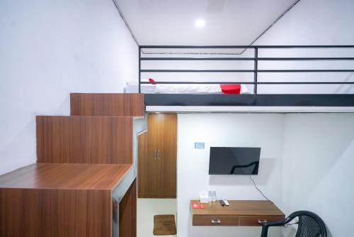 LampungRedDoorz at Jalan Basuki Rahmat Lampung的小房间设有双层床和书桌