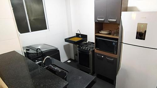 大坎普Apto Executivo Ravena的一间带冰箱和炉灶的小厨房