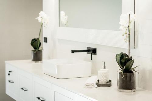 勒弗戴尔Whitevale Luxury Estate的白色的浴室,配有水槽和花朵
