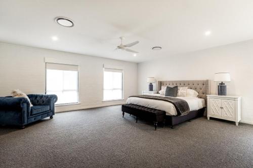 勒弗戴尔Whitevale Luxury Estate的一间卧室配有一张床、一把椅子和窗户。