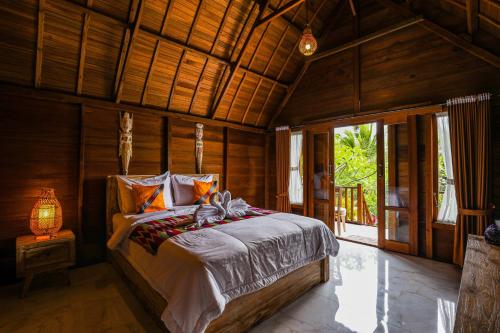 珀尼达岛The Tukad Gepuh Cottage and Resto的木制客房内的一间卧室,配有一张床