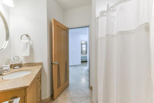 加尔维斯敦Galveston Luxury High Rise Oceanfront的浴室配有盥洗盆和带镜子的淋浴