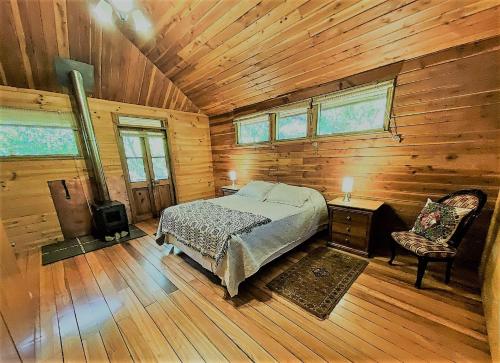 圣何塞德迈波Casa La Montaña的小木屋内的卧室,配有一张床和椅子
