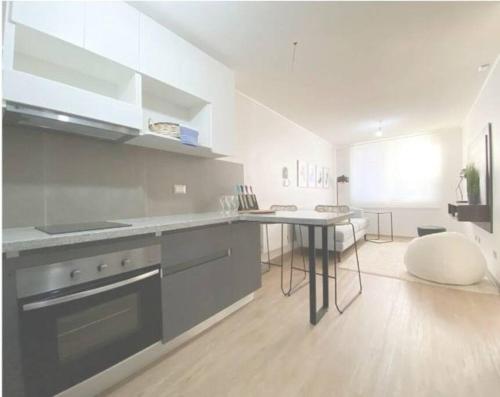 蒙特港408/ Precioso apartamento 1D+1B /(3 camas)/ JUMBO+CENTRO 5 MIN的厨房配有炉灶和桌子。