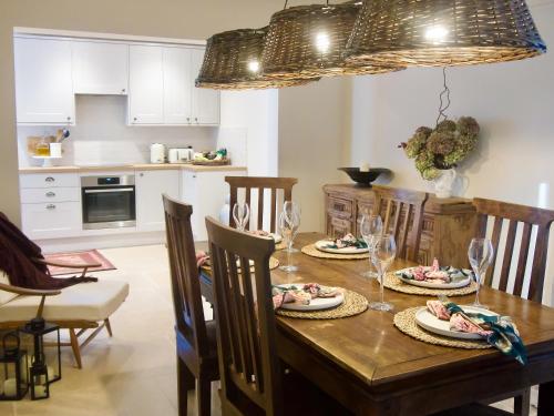 斯托克罗奇福德Oak Tree Cottage的厨房以及带木桌和椅子的用餐室。