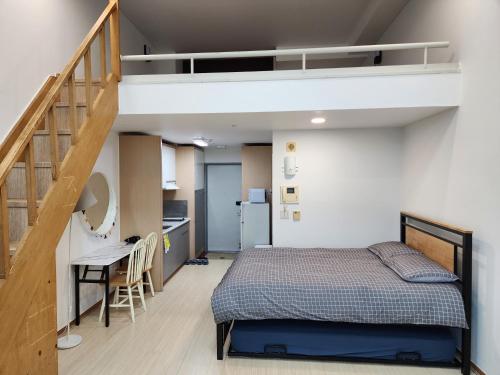 首尔JSM Studio Hongdae的一间卧室设有一张床和一个楼梯