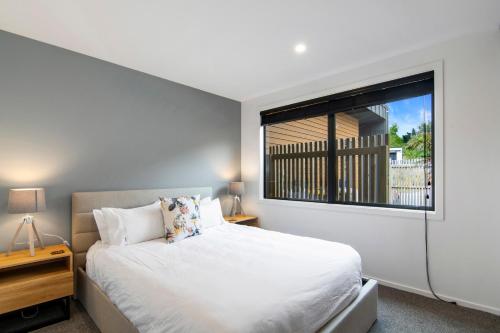 凯特里特里Kotuku Apartment - Kaiteriteri Holiday Unit的卧室配有白色的床和窗户。