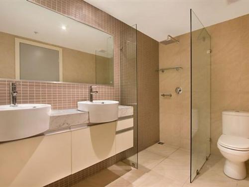 达尔文High Above, Pandanas Darwin 21st floor with views的浴室配有2个盥洗盆、卫生间和淋浴。