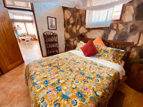 金贾HomeOnTheNile的一间卧室设有一张床和石墙