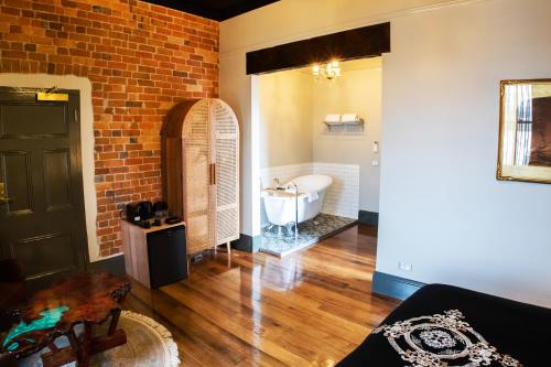 伊登Hotel Australasia的一间带砖墙和浴缸的浴室