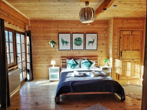 波兰尼卡-兹德鲁伊Pokoje i Domki Na Szlaku的木制客房内的一间卧室,配有一张床