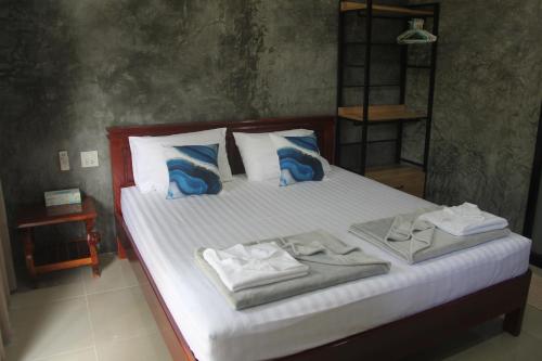 班泰Yangyai Garden Lodge的一间卧室配有带毛巾的床