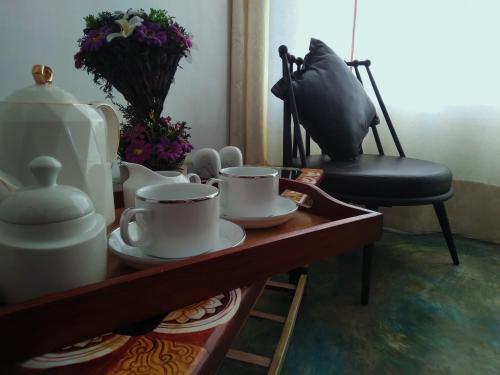 康提Barefoot Inn Kandy的桌子,上面有杯子,盘子,椅子