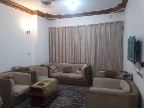 法尤姆Azzam Guest House 2 families only的客厅配有两张沙发和一台电视机