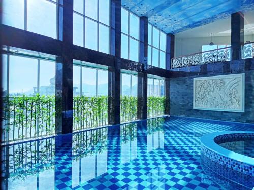 TakengonGrand Bayu Hill Hotel的一座带窗户的建筑中的游泳池