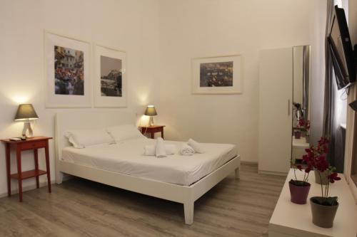 佛罗伦萨青铜马酒店的白色卧室配有白色的床和2张桌子