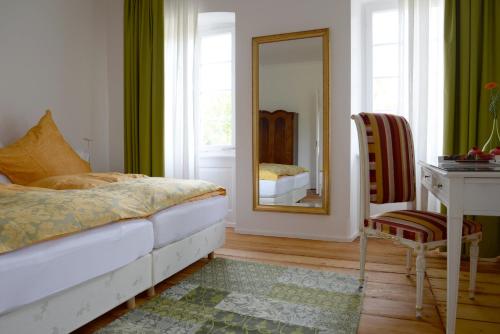 卡尔斯巴德阿尔特阿波蒂克住宿加早餐旅馆的一间卧室配有一张床、镜子和一张书桌