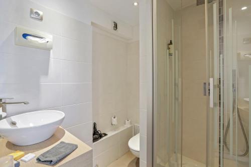 鲁昂Urban Style hotel de l'Europe的一间带水槽和玻璃淋浴的浴室