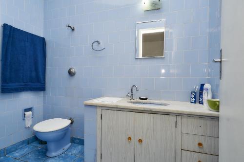 坎皮纳斯Deck Hostel Taquaral的蓝色的浴室设有卫生间和水槽