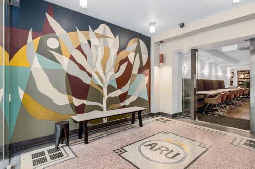 墨尔本布尔科高地酒店的壁画,房间带长凳和桌子
