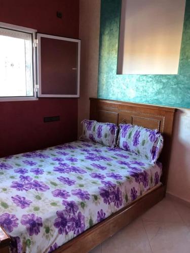 非斯مولاي عقوب的一间卧室,床上有紫色鲜花